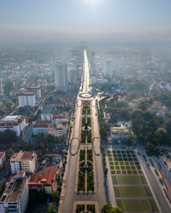 Naklejka premium Backlit aerial view of Thai Nguyen city's central roundabout, with long shadows and sun glare, showcasing urban life under bright sunlight.