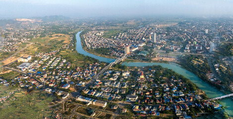 Naklejka premium Aerial view of the Ben Tuong Bridge, an arch bridge spanning the Cau River in Thai Nguyen city, with its reflection in the water.