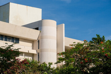 Fototapeta premium Facade of a 1970s old tropical brutalism building with cylindrical concrete wall under a clear blue sky in George Town, Penang, Malaysia.