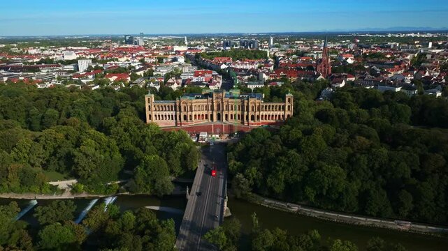 An aerial drone view of the Maximilianeum, the grand historic building that houses the Bavarian State Parliament, located on the banks of the River Isar in Munich, Germany. 