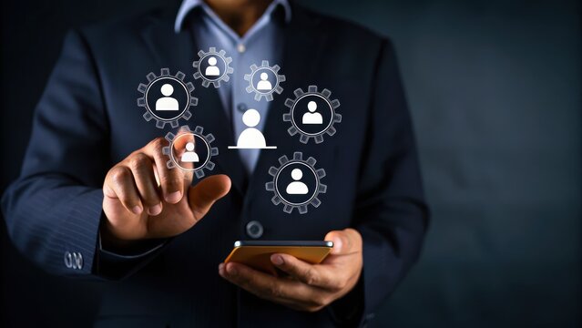 A businessperson uses a smartphone and interacts with virtual icons representing networked people and gears.