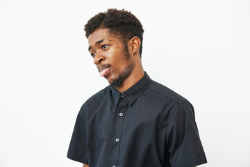 Black man with a stylish haircut, wearing a black shirt and showing a thoughtful expression....