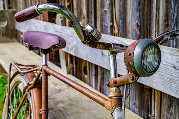 Vintage blue bicycle leaning against a colorful wall in bright sunlight during afternoon hours in...