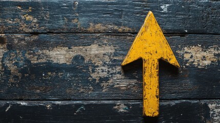 Yellow Arrow Symbol on Weathered Dark Wooden Surface Signifying Direction and Navigation for Various Applications in Marketing and Design