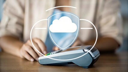 A person uses a payment terminal, with a digital cloud security icon overlay, symbolizing secure cloud-based transactions.