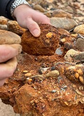 hands working with organic raw clay at a beach