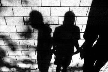 Shadow silhouette of young people standing on city street sidewalk