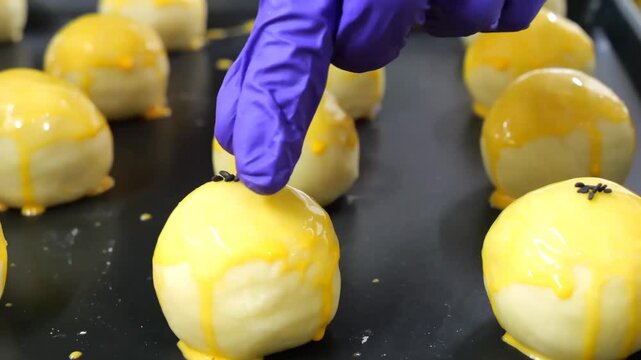 Applying cumin seeds on egg yolk coated dough balls enhances aroma and taste before baking