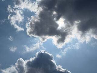 Dramatic cloudy sky with sun rays breaking through dark clouds
