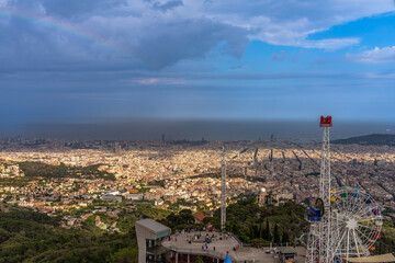 Aerial panorama view of Barcelona city with ferris wheel of the amusement park on top of moutain Tibidabo in summer with blue sky, Barcelona, Catalonia, Spain