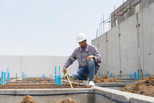 Construction site. Building foundation structure. Civil engineer. Network of pipes. Construction engineer supervising construction work at construction site. Plumber working in sewer pipes area