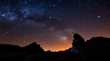 Couple Embracing Under the Milky Way in a Dark Mountain Landscape