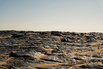 Ash-covered hills in Egypt's Black Desert under a clear sky, scenic and remote landscape. Volcanic	