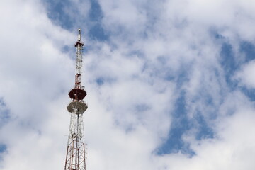 A telecommunications tower stands against a cloudy sky, showcasing technology that connects people