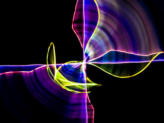 colorful light trails in dark background. Abstract light routes that rotate in vibrant colors....