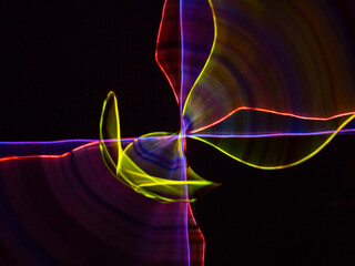 colorful light trails in dark background. Abstract light routes that rotate in vibrant colors....