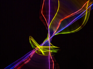 colorful light trails in dark background. Abstract light routes that rotate in vibrant colors....