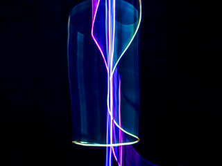 colorful light trails in dark background. Abstract light routes that rotate in vibrant colors....