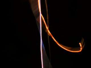 colorful light trails in dark background. Abstract light routes that rotate in vibrant colors....