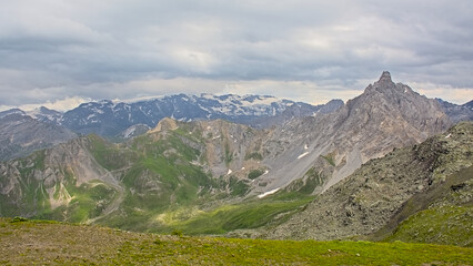 Fototapeta premium Mountains with glaciers under a cloudy sky in La Vanoise national park, Savoie, France 