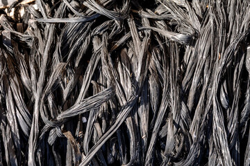 Close-up of melted plastic fibers – Abstract lines and patterns from burned material in black and gray color