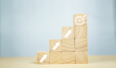 Wooden blocks arranged in ascending steps with a target icon at the top, representing success,...