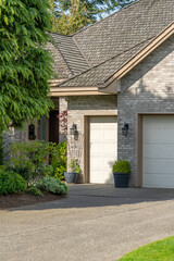 Garage door in luxury house with trees and nice landscape in Spring in Vancouver, Canada, North America. Day time on May 2025.