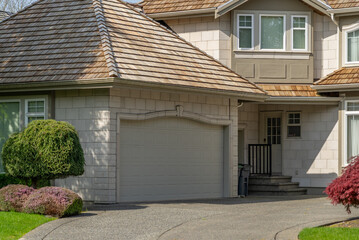 Garage door in luxury house with trees and nice landscape in Spring in Vancouver, Canada, North...