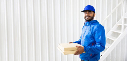 Delivery Man : Portrait of asian indian friendly deliveryman man in uniform with a cartboard box