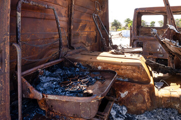 Burnt-out and rusted truck – destroyed interior of a vehicle on an abandoned industrial site