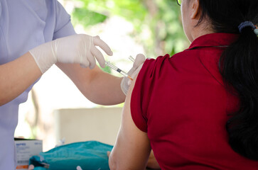 Concept of vaccination against epidemic, woman wearing medical face mask is getting vaccinated against epidemic at hospital medical center