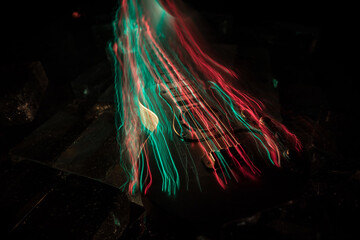 Music Concept: Guitar Miniature on a Dark Background with Vivid Light, Smoke, and Fire Effects. Golden electro guitar under a Dramatic Spotlight.