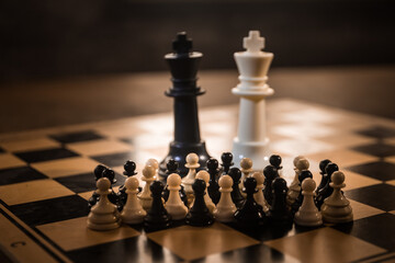 Chess board game concept of business ideas and competition and strategy ideas concep. Chess figures on a dark background with smoke and fog. Selective focus
