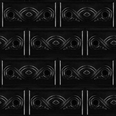 Seamless 4k photo texture material of black plastic tile surface with ornate pattern.