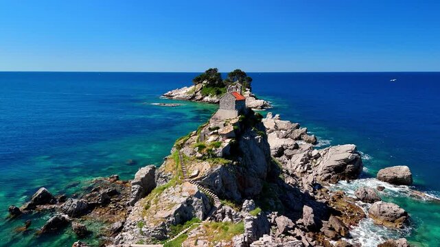 Aerial drone view of the Sveta Nedelja church in Montenegro. A Christian church on a tiny rocky island in the sea near the town of Petrovac.