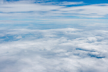 Vivid photo of clouds and sky from an airplane window.
