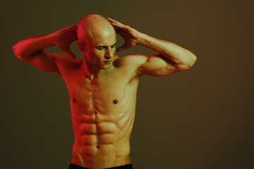 Muscular man posing with expressive gestures, showcasing a strong physique. This vibrant image...