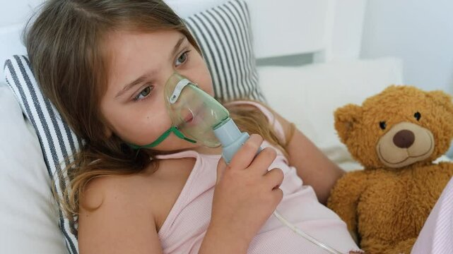 Caucasian child breathing nebulaser, face in inhalation mask.Cough treatment. Asthma and bronchospasm.