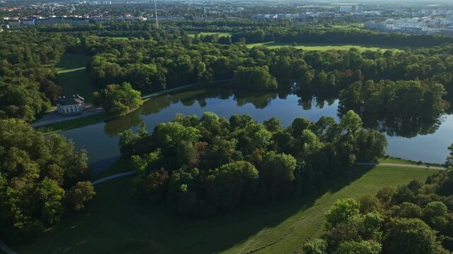 Aerial drone view of Badenburger See in Schlosspark Nymphenburg, Munich, Germany, surrounded by greenery and historic charm .