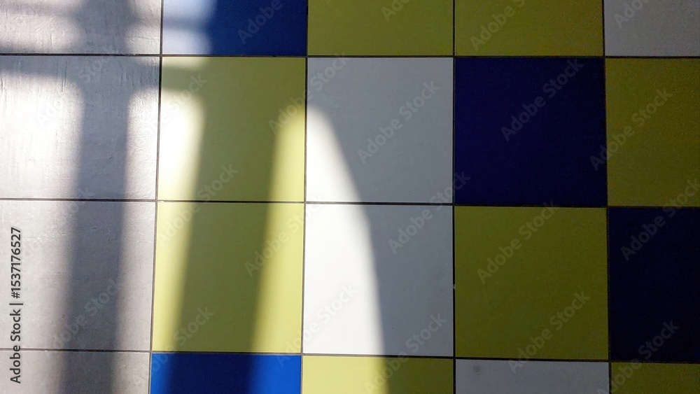 Poster Colorful Tiled Floor With Shadow Patterns Creating Visual Contrast in a Well-Lit Space