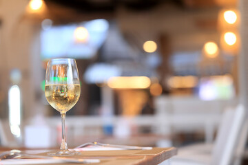 a glass of cold white wine and serving in the restaurant