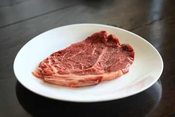 a piece of raw meat, steak on a plate, beef