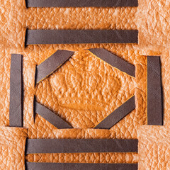 Seamless 4k photo texture material of light brown leather with crown embossing and ornate inserts.