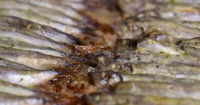 stacked in rows cooked hot capelin baked in sunflower oil in the oven, close up