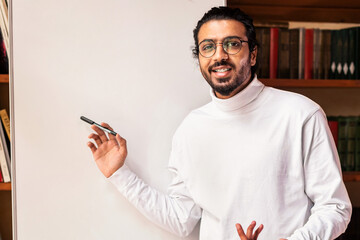 Knowledge And Education. Indian Male Teacher Teaching Online Pointing To Blackboard With English...