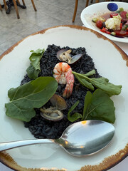 Cuttlefish black risotto with shrimp and infish served at restaurant