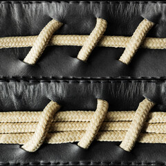 Seamless 4k photo texture material of black leather with rope braided insert and stitches.