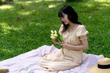 Beautiful young woman in a summer dress holding a bouquet