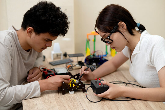 Asian Young men and women are interested in inventing - Powered by Adobe