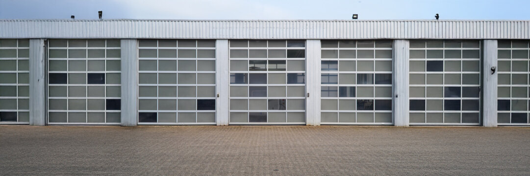 Panoramic view, row of sectional garage doors closing a storage building
